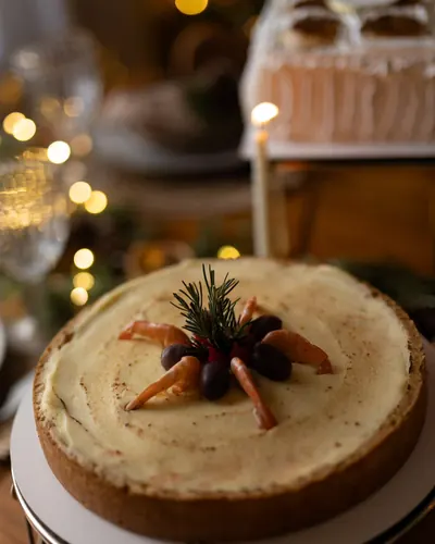Torta inteira com creme dourado, camarões, azeitonas pretas e alecrim