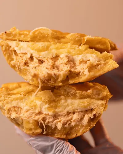 Torta de frango cortada ao meio, com recheio cremoso de frango desfiado